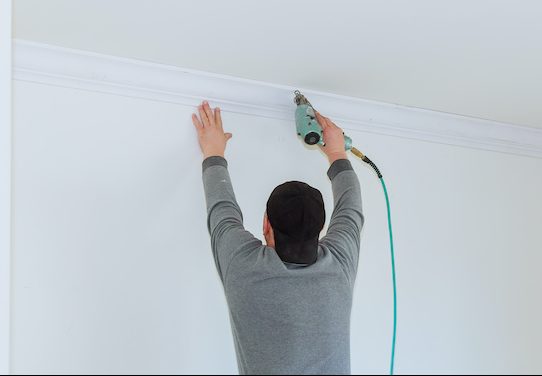 man installing crown molding