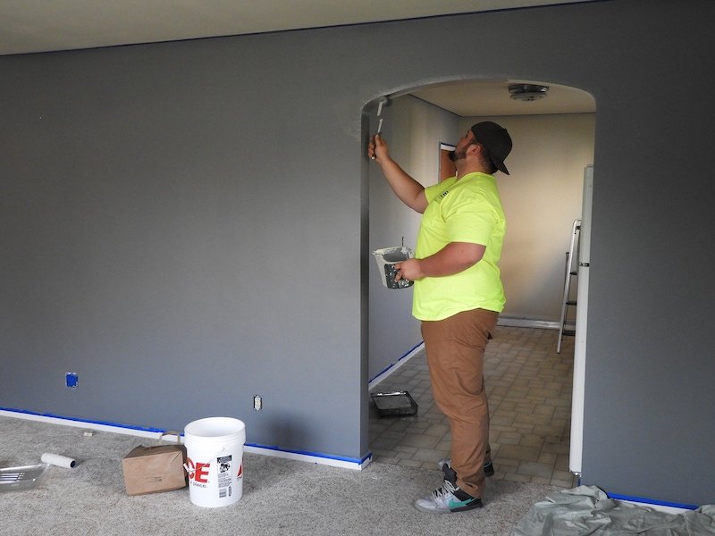 man painting inside of door frame