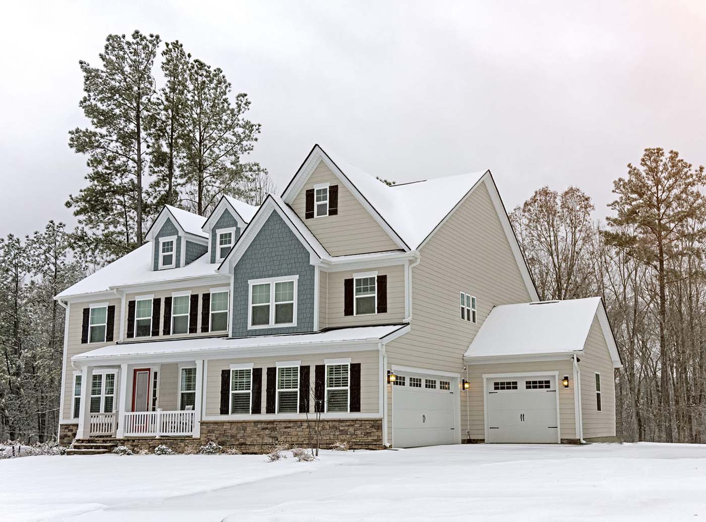 Northeastern home with off-white siding covered in snow